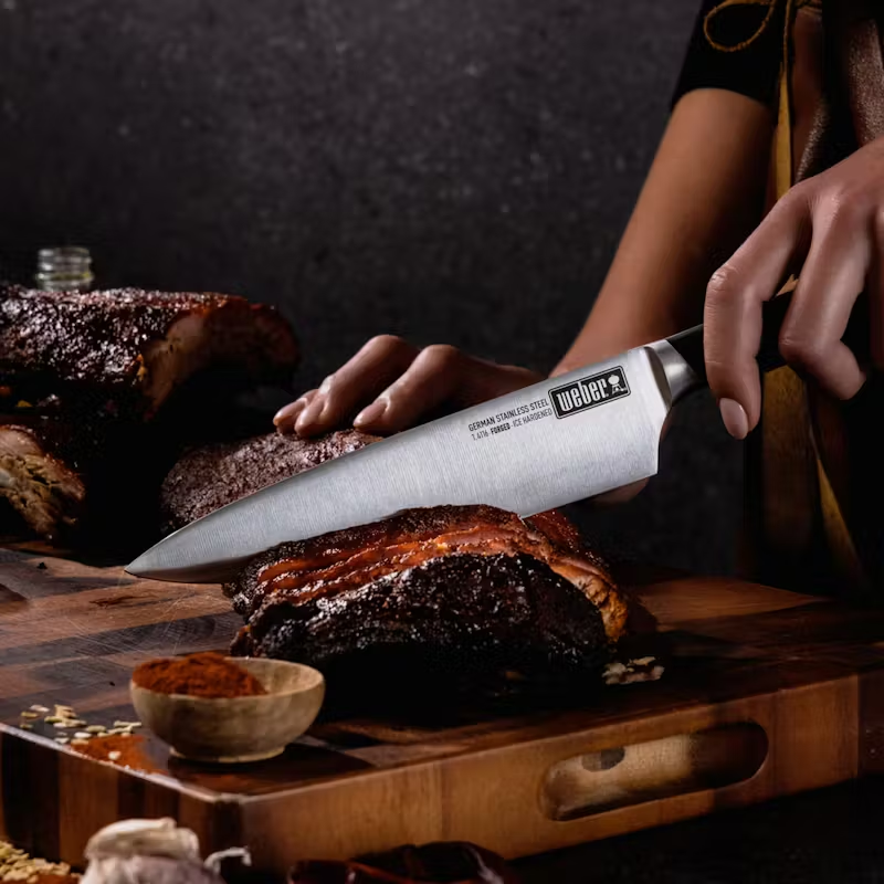 Chefs Knife 2 German steel cold forged Chefs knife cutting through pork ribs.