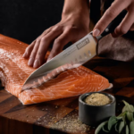 Santoku Knife 2 German steel cold forged Santoku knife cutting through salmon.